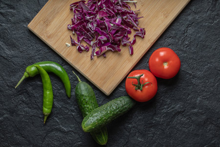 Vegetables mix. chopped cabbage, cucumber, tomato and pper on black background