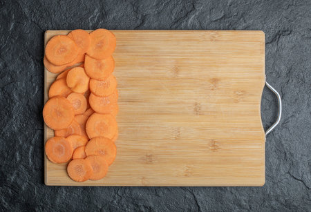 Close up of a pile of cut carrots on a wooden bamboo cutting boardの写真素材