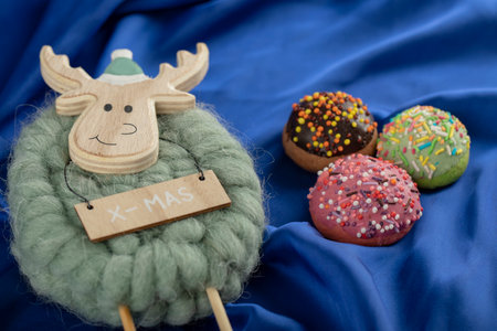 Colorful sweet doughnuts with Christmas deer toyの写真素材
