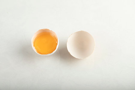 Broken organic egg on white background