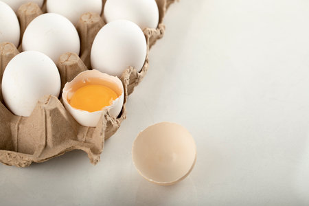 Uncooked chicken eggs in a carton container