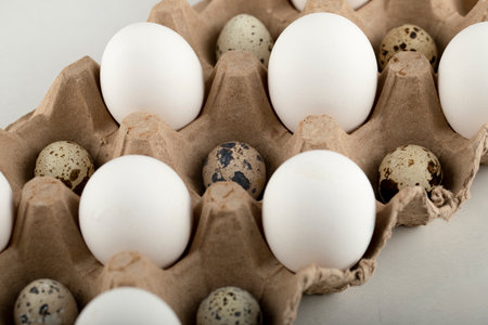 Raw chicken and quail eggs in a carton container