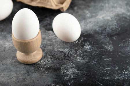 A wooden eggcup with boiled chicken egg