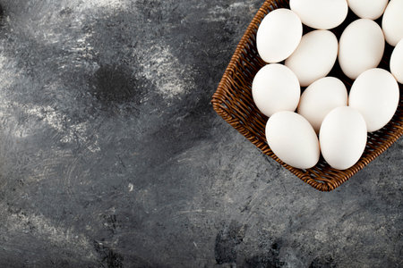 A wooden wicker full of white raw chicken eggsの写真素材