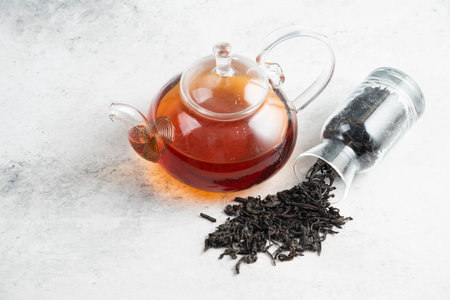 Dry tea leaves with teapot on a marble backgroundの写真素材