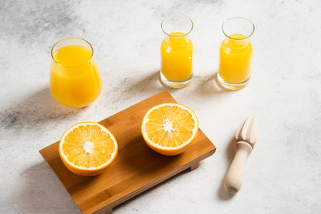 A glass cups of fresh juice with slices of orangeの写真素材