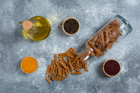 A glass bottle of oil with raw macaroniの写真素材