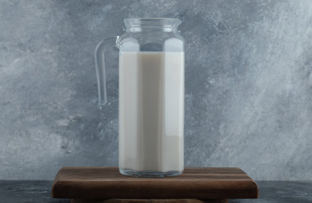 Jug of fresh milk on wooden boardの写真素材