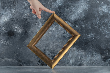 Female hand touching picture frame on marble background