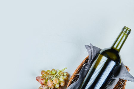 Bunch of grapes and a bottle of wine on gray backgroundの写真素材