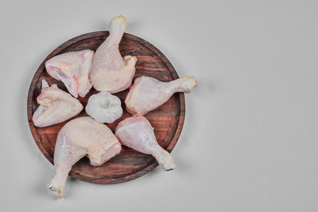 Raw chicken meat parts on wooden plateの写真素材