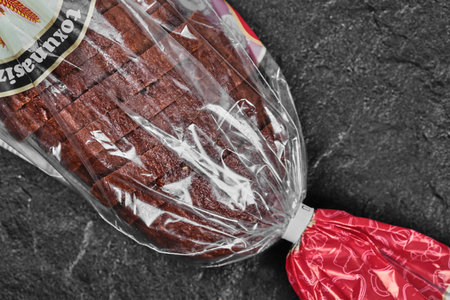 Sliced black rye bread in plastic bag on dark backgroundの写真素材