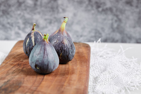 A plate of purple figs on a marble background