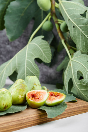 Figs with red seeds on a wooden platterの写真素材
