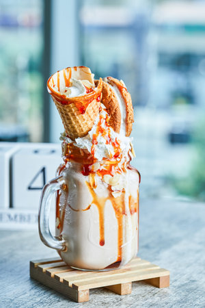 Caramel ring milkshake in the wooden plate on the marble backgroundの写真素材