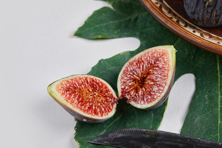 A purple figs with red seeds on a green leafの写真素材
