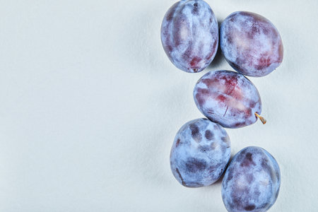 Group of fresh plums on a blue backgroundの写真素材