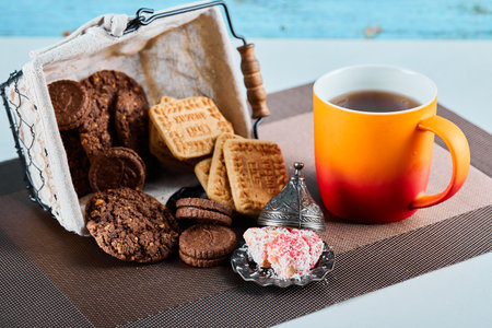 Assorted biscuits, candies and a cup of tea on gray backgroundの写真素材