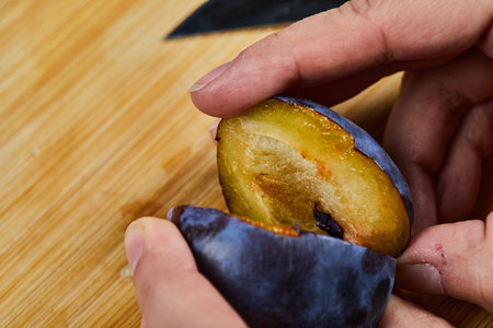 Holding fresh plum on wooden boardの写真素材