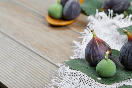 Ripe fresh figs on a wooden table with a wooden spoonの写真素材