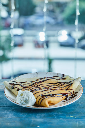 Pancakes with vanilla ice-cream, chocolate on the white plate in the blue backgroundの写真素材