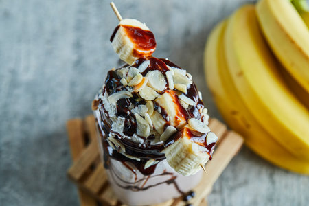 Chocolate smoothie with choco syrup and branch of bananasの写真素材