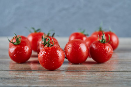 Bunch of fresh juicy tomatoes on wooden tableの写真素材