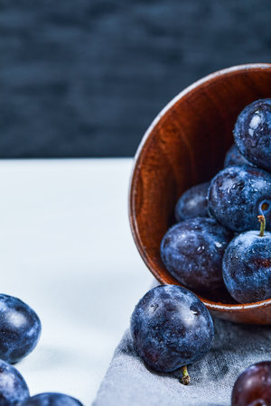 Bowl of garden plums on white and dark backgroundの写真素材