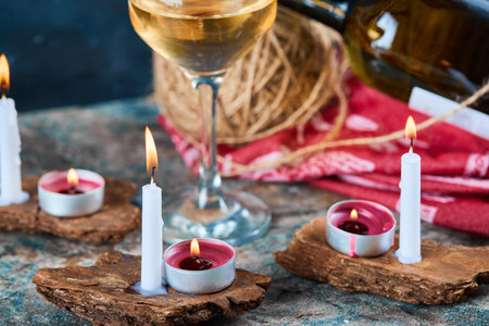 Glass of white wine and candles on marble tableの写真素材