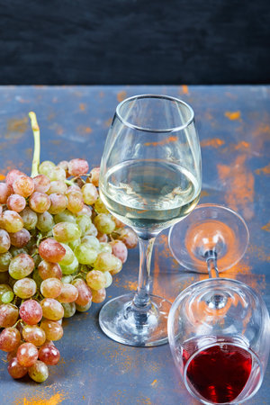 Bunch of grapes and glasses of wine on blue backgroundの写真素材