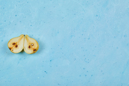 Half cut ripe pear isolated blue backgroundの写真素材