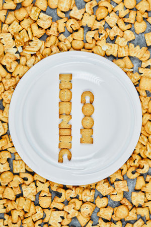 Scattered alphabet crackers and good morning spelled with crackers on a white plateの写真素材