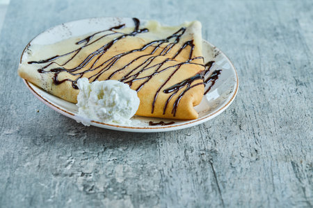Pancakes with vanilla ice-cream, chocolate on the white plate in the marble backgroundの写真素材