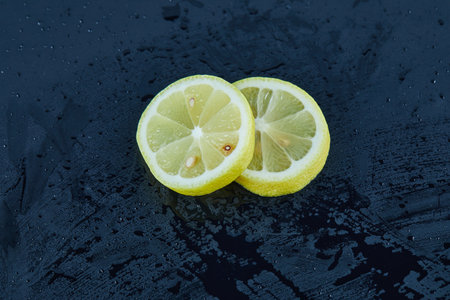 Two juicy yellow lemon slices on blue background