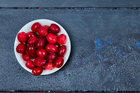 Bunch of cornel berries on white plate. Top viewの写真素材