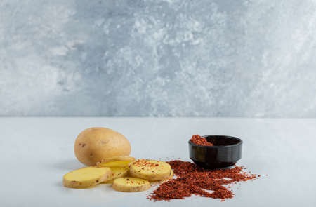 sliced or whole potatoes and red chili pepperの写真素材