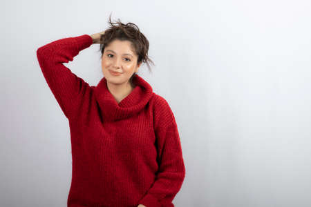 Photo of a pretty young woman in warm red sweater posingの写真素材