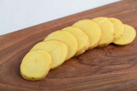 Stack of Sliced potato on brown wooden boardの写真素材
