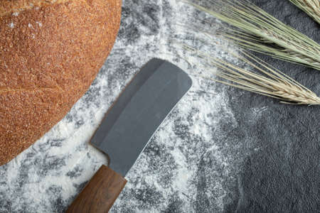 Close up photo of freshly baked bread and knifeの写真素材