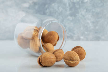 A glass jar full of sweet walnut shaped cookies