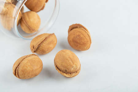 A glass jar full of sweet walnut shaped cookiesの写真素材