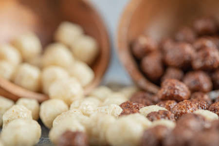 Wooden bowls with sweet corn balls on a gray background