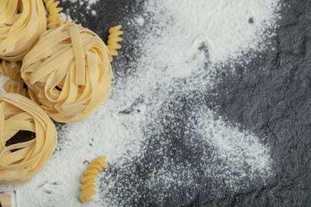 Raw nest noodles with flour on a dark backgroundの写真素材