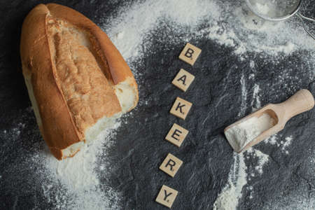 A wooden spoon with flour and wooden lettersの写真素材