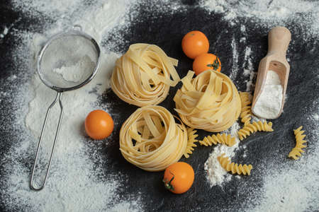 Raw nest noodles with flour on a dark backgroundの写真素材