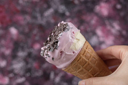 Holding a blueberry icecream in waffle cone