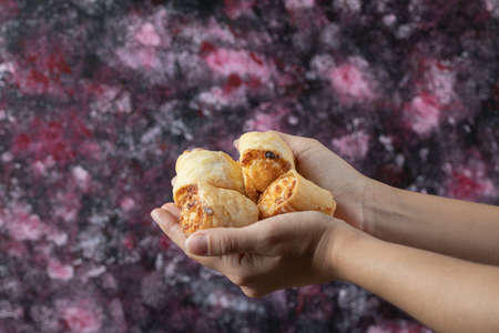 A chef holding butter cookies in the hand