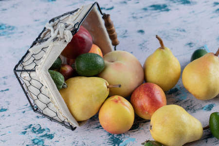 Mixed autumn fruits out of a metallic basketの写真素材