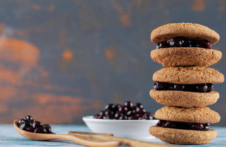 Crispy oatmeal cookies with blackcurrant berry confiture on it