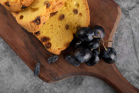 Sultana pie slices on a wooden platter with a bunch of red grapesの写真素材